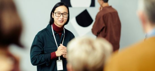 a man leads a group on a tour of an art museum